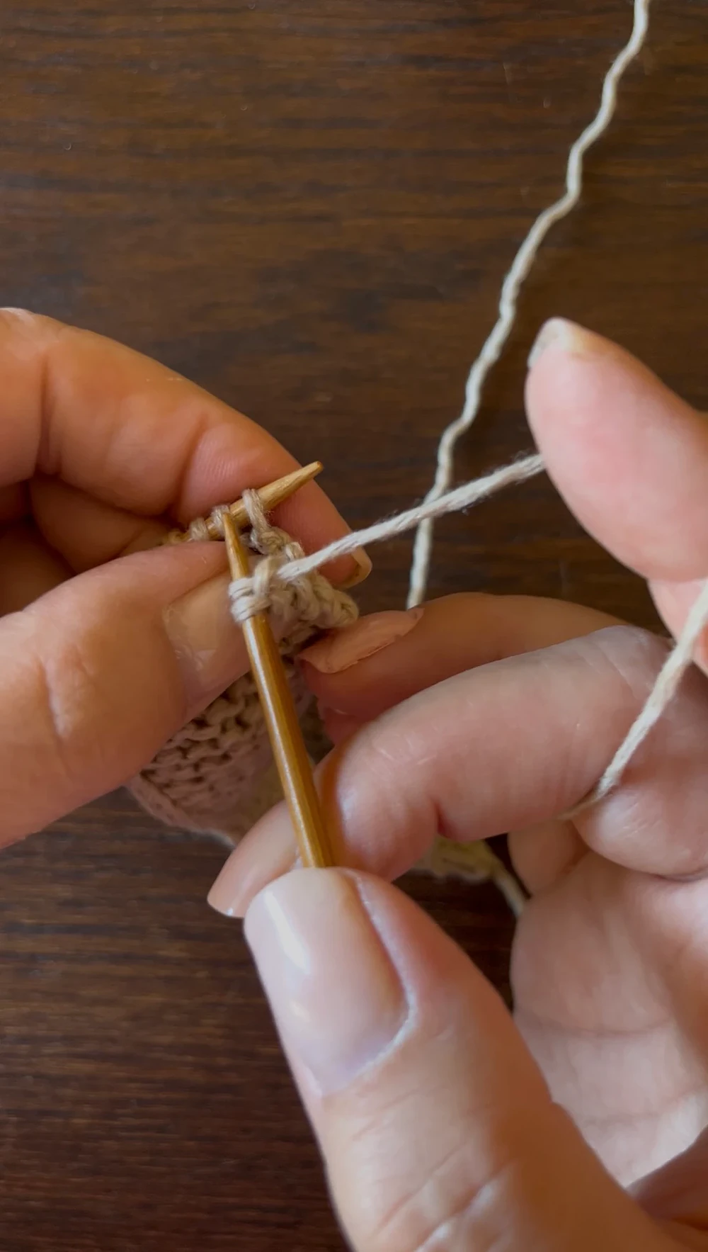 Le mani che lavorano il cashmere ai ferri.